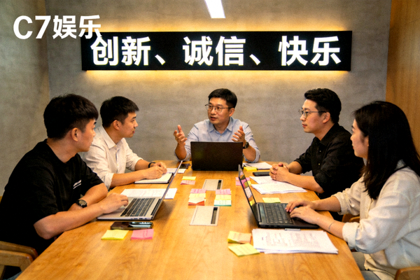 C7娱乐团队正在讨论使命与愿景的会议场景，墙上挂着‘创新、诚信、快乐’的标语